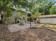 Large backyard featuring a concrete patio, basketball hoop, detached garage, and stair access at 5604 N Cherokee Ave, Tampa, FL 33604