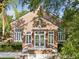 Charming brick building with white windows and door, surrounded by lush trees and professional landscaping at 5604 N Cherokee Ave, Tampa, FL 33604
