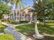 View of charming brick building with white windows, walkway, mature trees, and manicured lawn at 5604 N Cherokee Ave, Tampa, FL 33604