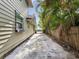 Long driveway on the side of a home with palm trees and a wooden fence providing privacy at 5604 N Cherokee Ave, Tampa, FL 33604
