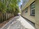 Driveway on the side of a home with trees on the right and lush vegetation on the left at 5604 N Cherokee Ave, Tampa, FL 33604