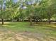 View of grassy common area dotted with mature trees providing ample shade and a relaxing atmosphere at 5604 N Cherokee Ave, Tampa, FL 33604