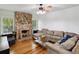 Cozy living room features a stone fireplace, hardwood floors, and neutral furnishings at 5604 N Cherokee Ave, Tampa, FL 33604