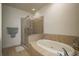 Elegant bathroom showcasing a soaking tub and glass shower with neutral tile at 611 Bella Loop, Dunedin, FL 34698