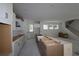 Bright kitchen with white cabinets, farmhouse sink, island, and an adjacent staircase, blending modern design at 615 48Th N Ave, St Petersburg, FL 33703
