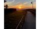 Sunset view, boardwalk leading to the beach with ocean views and golden light at 718 Bay Esplanade, Clearwater Beach, FL 33767