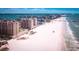 Picturesque beach view featuring high-rise buildings, soft sand, and clear turquoise waters at 718 Bay Esplanade, Clearwater Beach, FL 33767