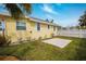 Back exterior of yellow home shows a small stone paver patio and white trim at 718 Bay Esplanade, Clearwater Beach, FL 33767