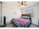 Cozy bedroom features a ceiling fan and a comfortable bed with a soft, purple blanket at 8137 Greenside Ln, Hudson, FL 34667
