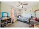 Comfortable bedroom with a ceiling fan, bright window view, and closet storage space at 8137 Greenside Ln, Hudson, FL 34667