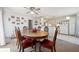 Cozy dining room featuring wood table, red cushioned chairs, ceiling fan, and bright natural light at 8137 Greenside Ln, Hudson, FL 34667