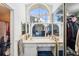 Bright bathroom with a large vanity, arched window, and a view of the main bedroom at 8137 Greenside Ln, Hudson, FL 34667