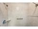 Tiled shower stall with adjustable shower head, grab bar, and soap dish at 8137 Greenside Ln, Hudson, FL 34667