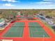 Aerial view of well-maintained tennis courts with surrounding trees and ample parking at 8137 Greenside Ln, Hudson, FL 34667
