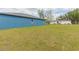 A spacious backyard with lawn stretching to the bright blue house, and a mobile home in back at 9510 Xenia St, New Port Richey, FL 34654