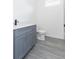 Bathroom featuring gray vanity with white countertop and toilet at 9510 Xenia St, New Port Richey, FL 34654