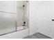 Clean bathroom featuring a tub with glass shower doors and modern fixtures at 9510 Xenia St, New Port Richey, FL 34654
