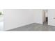 This bedroom offers neutral paint, modern gray flooring, and a view to an additional room at 9510 Xenia St, New Port Richey, FL 34654