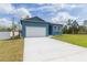 Bright blue single-story home featuring a two-car garage and well-manicured lawn at 9510 Xenia St, New Port Richey, FL 34654