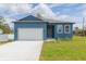 Charming blue single-story home with a well-maintained lawn and a paved driveway at 9510 Xenia St, New Port Richey, FL 34654