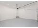 Large open garage featuring an epoxy floor, utility door, and steps to the main house at 9510 Xenia St, New Port Richey, FL 34654