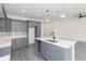 Spacious kitchen featuring an island with sink, gray cabinetry, and modern pendant lighting at 9510 Xenia St, New Port Richey, FL 34654