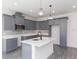 Modern kitchen featuring gray cabinets, white countertops, a stylish island, and stainless steel appliances at 9510 Xenia St, New Port Richey, FL 34654
