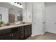 Bathroom with dual sinks, granite countertops, and dark cabinetry at 1088 Belvoir Way, Spring Hill, FL 34609