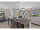 Kitchen island with granite countertop and stainless steel dishwasher overlooking the dining and living area at 1088 Belvoir Way, Spring Hill, FL 34609