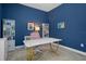 Bright office with blue walls, white shelving, and modern gold-legged desk at 1088 Belvoir Way, Spring Hill, FL 34609