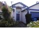 Home exterior featuring a blue front door, blue trimmed roof and gutters with a white facade at 11019 Connacht Way, Tampa, FL 33610