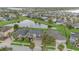 Expansive aerial view of a neighborhood featuring homes surrounding a central pond and lush greenery at 11330 Lake Lucaya Dr, Riverview, FL 33579