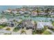 Aerial view of the home with a screened lanai, lush backyard, boat dock on a canal lined with luxury homes at 116 9Th E St, Tierra Verde, FL 33715
