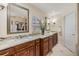 Bright bathroom featuring granite countertops, double sinks, and decorative mirror at 116 9Th E St, Tierra Verde, FL 33715