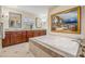 Bathroom with jacuzzi tub, marble countertop, wood cabinets, and an art piece at 116 9Th E St, Tierra Verde, FL 33715