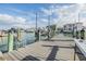 Dock featuring wood decking, steel ladders, and boat lifts set among waterfront homes on a sunny day with blue sky at 116 9Th E St, Tierra Verde, FL 33715