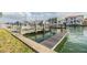Image featuring a boat dock with weathered wood and concrete supports, on a sunny day with still, green canal water at 116 9Th E St, Tierra Verde, FL 33715