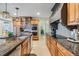 A kitchen with stainless steel appliances, granite countertops, wood cabinets, and tile backsplash at 116 9Th E St, Tierra Verde, FL 33715