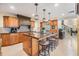 Kitchen island with granite countertop, pendant lights, wood cabinets, and barstool seating at 116 9Th E St, Tierra Verde, FL 33715