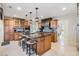 A kitchen featuring wood cabinets, granite countertops, pendant lighting, and island with barstool seating at 116 9Th E St, Tierra Verde, FL 33715