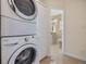 Laundry area with stacked washer and dryer, plus bathroom access at 116 9Th E St, Tierra Verde, FL 33715
