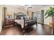 Main bedroom with hardwood floors, natural light, ceiling fan, and wrought iron bed frame at 116 9Th E St, Tierra Verde, FL 33715