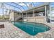 Inviting pool with brick pavers and screened enclosure, offering a refreshing outdoor escape with ample sunlight at 116 9Th E St, Tierra Verde, FL 33715