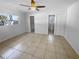 Bright main bedroom with neutral tile flooring, ceiling fan, and en-suite bathroom at 11779 82Nd Ter, Seminole, FL 33772