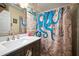 Charming bathroom featuring a marble vanity, decorative accent wall, and a novelty shower curtain at 1224 Cressford Pl, Brandon, FL 33511