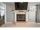 Close-up of a classic fireplace with tile and white trim, featuring a mounted TV and tulip art above at 1224 Cressford Pl, Brandon, FL 33511