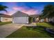 Charming single-Gathering home with a two-car garage and landscaped front yard under a colorful twilight sky at 1224 Cressford Pl, Brandon, FL 33511