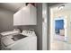 Laundry room featuring white cabinets, modern washer and dryer, and tile floors at 1224 Cressford Pl, Brandon, FL 33511