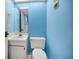 Bathroom with a white toilet and sink against blue walls at 12340 Capri N Cir, Treasure Island, FL 33706