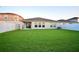 Large, verdant backyard featuring a covered patio and pristine green lawn, ideal for outdoor activities at 12820 Bent Twig Dr, Riverview, FL 33579